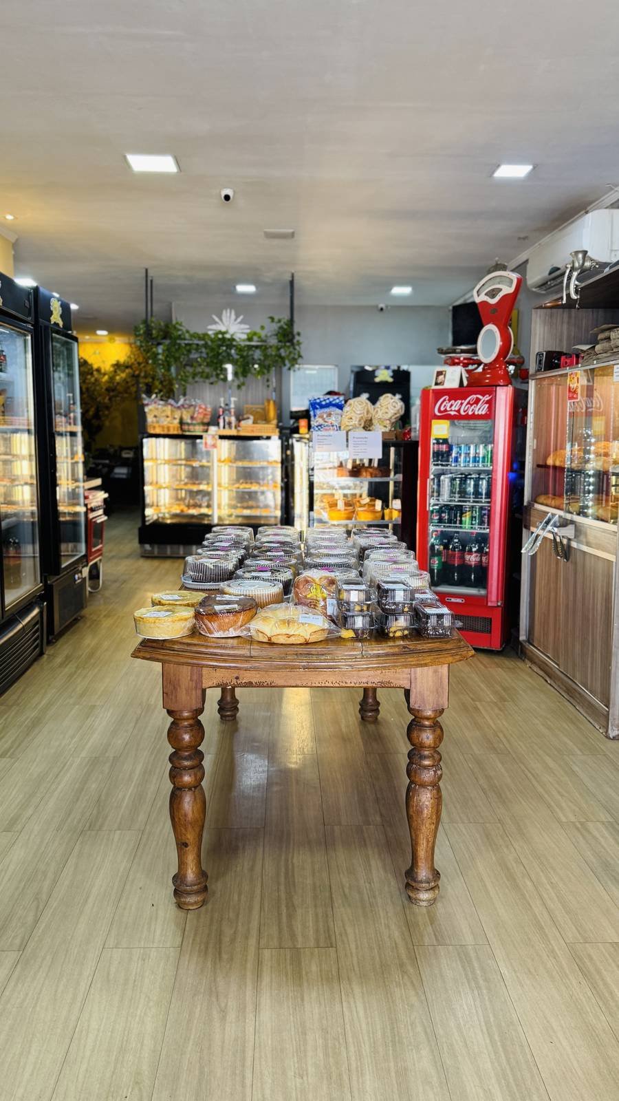 Interior da padaria Tia Ju com vitrines de pães e doces